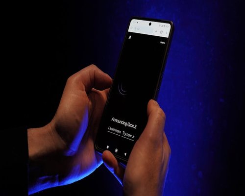 Person holding a smartphone in a dark room with night mode on